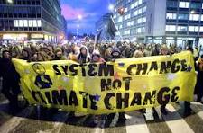 Demonstrates use in climate marches of the phrase: "System Change Not Climate Change"